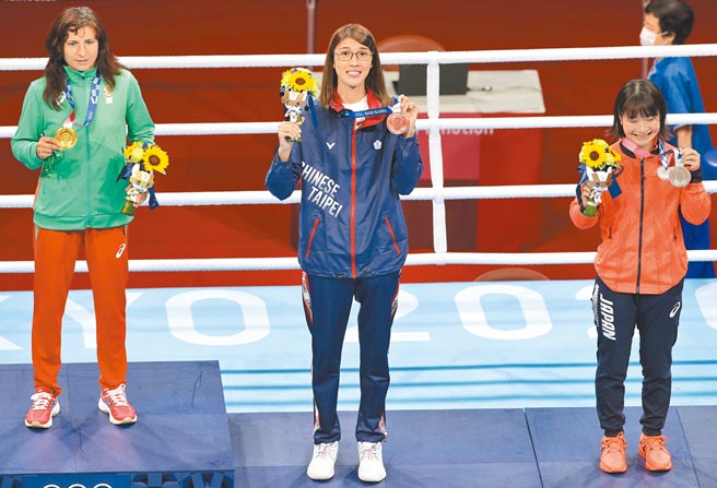 黄筱雯（中）在拳击女子51公斤级夺铜，她兴奋展示奖牌。（季志翔摄）