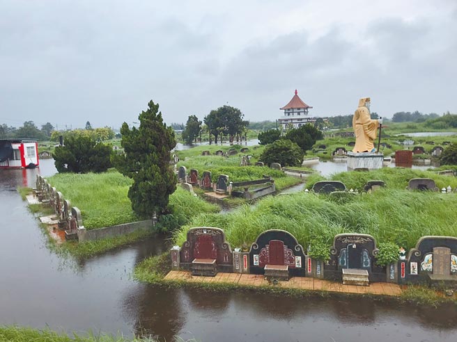 云林县沿海乡镇积水未退，台西乡坟墓泡水先人受罪。（张朝欣摄）