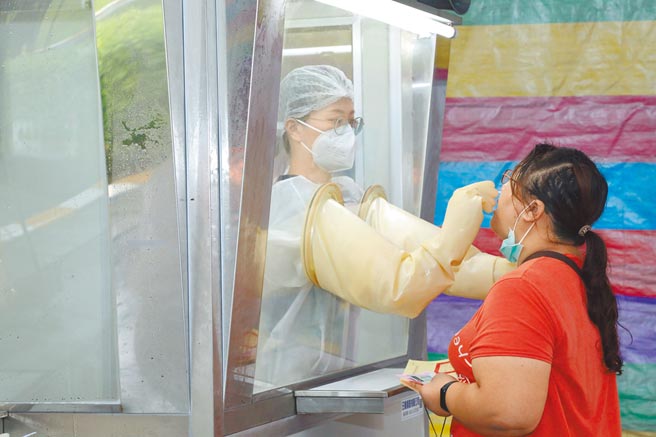 嘉义县民雄乡出现确诊案例，民眾昨天冒雨到扩大筛检站採检。（廖素慧摄）