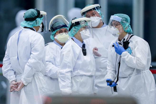 檢疫工作人員在包機抵達前就已換上全套防護裝備待命，等到旅客下機量測體溫，完成線上申報及資料審查後，將由協勤人員分5梯次引導旅客搭乘防疫車輛前往集中檢疫所，並在集中檢疫所進行採檢作業。（陳麒全攝）