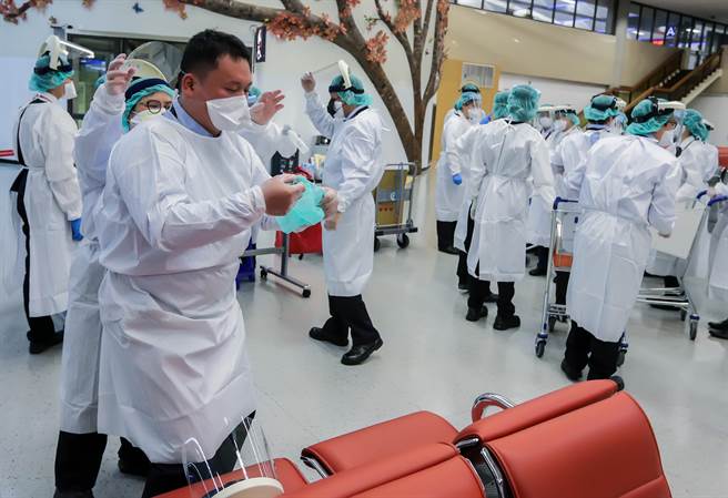 檢疫工作人員在包機抵達前就已換上全套防護裝備待命，等到旅客下機量測體溫，完成線上申報及資料審查後，將由協勤人員分5梯次引導旅客搭乘防疫車輛前往集中檢疫所，並在集中檢疫所進行採檢作業。（陳麒全攝）