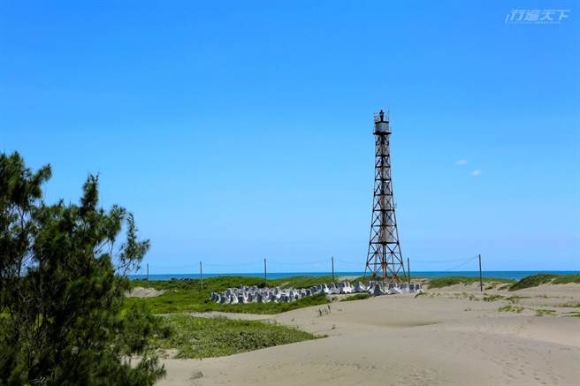 台灣本島最西端的國聖燈塔，以鐵塔方式建造，高度約32.7公尺，燈塔立於滾滾黃沙的沙丘上，地形荒涼猶如沙漠。（圖/行遍天下）
