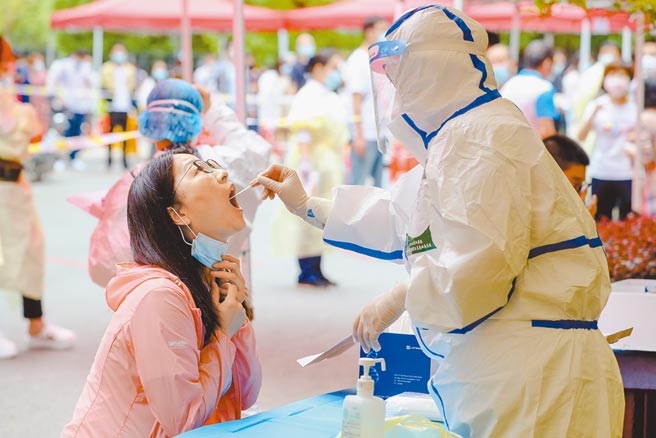 5月16日，在武汉洪山区保利蓝海郡小区检测点，工作人员对市民进行咽拭子採样。（中新社）
