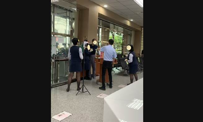 女行员遭挟持，其他行员与保全不断安抚嫌犯情绪。（图／翻摄自「记者爆料网」）。　