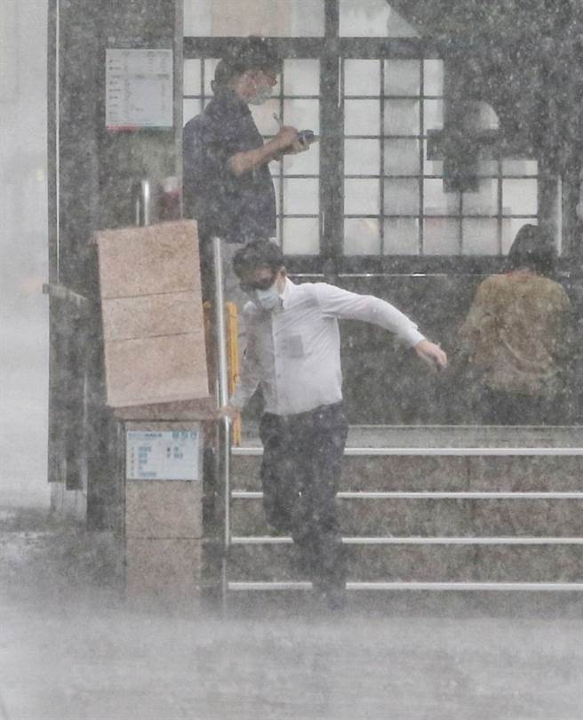 台北市午後大雷雨讓行人措手不及，全身溼透。（趙雙傑攝）