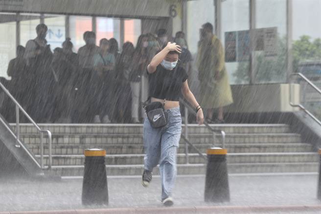 台北市午後雷陣雨讓西門町行人措手不及，許多沒帶雨具的民眾只能暫時躲在捷運站裡。（杜宜諳攝）