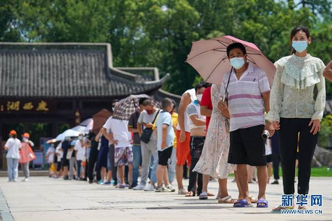 扬州市民在瘦西湖街道五亭社区瘦西湖西门採样点排队，准备进行核酸检测。（新华社）