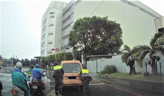 員警冒雨飛速馳援，雨中推車的背影，感動行經的人車，女駕駛直呼「揪甘心！」好險有人民保母即時救援，才不至發生追撞事故。（民眾提供／盧金足台中傳真）