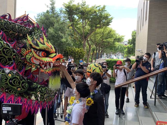 杨勇纬、林真豪观赏学弟妹舞龙表演后，特别准备红包感谢。(林欣仪摄)