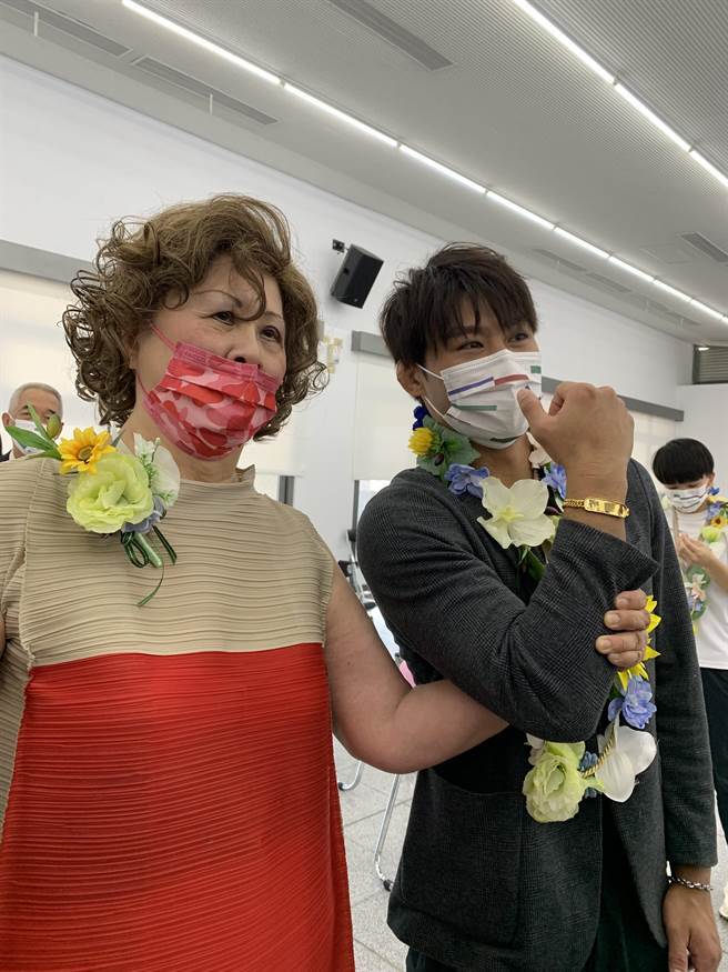 新民高中董事长刘昭惠(左)赠送杨勇纬金牌手炼，期许2024巴黎奥运能「手握金牌」。(林欣仪摄)