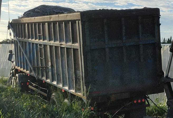 一辆满载废塑胶混合物曳引车于大内区头社里产业道路陷入泥泞动弹不得。（台南市环保局提供／刘秀芬台南传真）