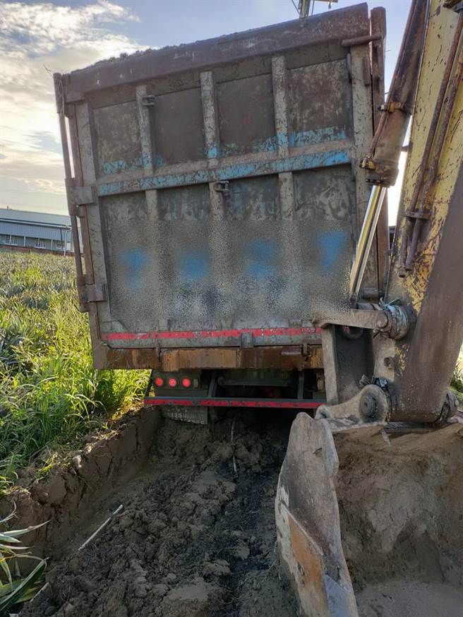 一辆满载废塑胶混合物曳引车于大内区头社里产业道路陷入泥泞动弹不得。（台南市环保局提供／刘秀芬台南传真）