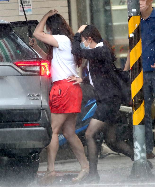 台湾北部13日午后对流旺盛下起强降雨，北市行人纷纷撑伞走避突来的阵雨。（郑任南摄）