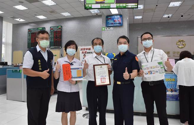 北市警南港分局长谢宗宏亲自到各金融机构，转颁市长柯文哲的感谢状及3000元礼卷。(翻摄照片／林郁平台北传真）