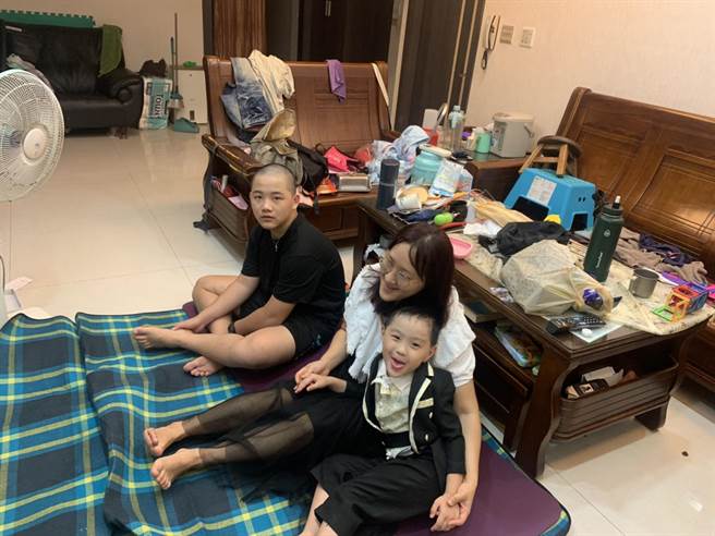 翔翔盛裝打扮，在家和媽媽一起觀看線上直播畢業典禮。（社會局提供）