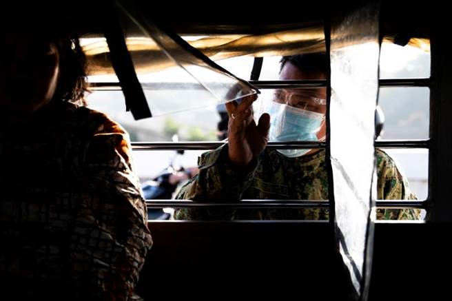 菲律賓雇主聯合會指封城非抗疫解方，呼籲政府開放經濟。圖為該國警察檢查通過檢查哨的車輛。（圖／路透社）