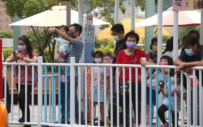 小朋友与家人排队等待使用游乐器材。（王英豪摄）
