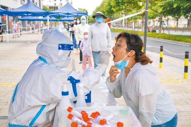 大陆江苏扬州全面排查有无市民仍未核酸检测，还提供检举属实者奖金。图为14日扬州市民排队核酸检测。（新华社）