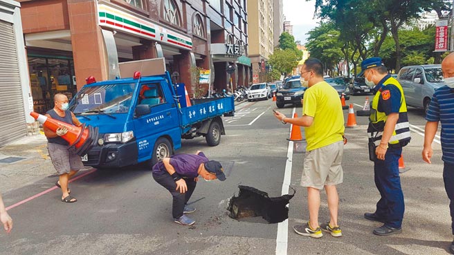 台中市南区忠明南路787号前机车道14日14时约44分出现深约1米的坑洞，造成1辆行驶经过的休旅车左前轮陷落。（民眾提供／冯惠宜台中传真）