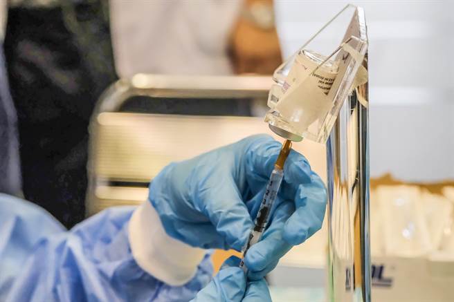 大安医院自创「精准抽药台」，将疫苗固定在台上，医护人员用双手稳定握住针管，能精准抽取0.5cc的疫苗剂量。（罗浚滨摄）