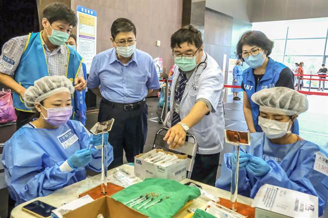 县长杨文科（左二）了解大安医院自创的「精准抽药台」，医护人员能快速精准抽取疫苗情形。（罗浚滨摄）