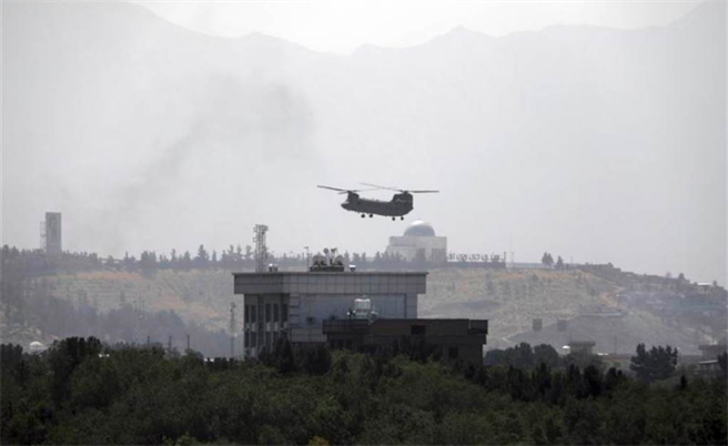 一架美军CH-47契努克直升机降落喀布尔美国大使馆，也有人看到疑似烧文件的烟雾，显然美国在阿富汗最后撤离行动已经进行。(图／美联社)