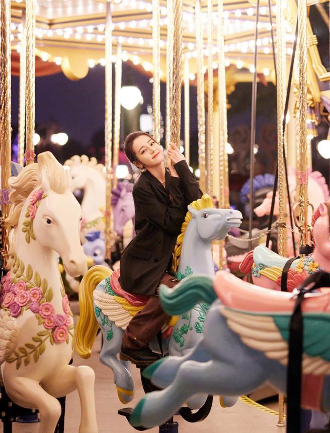 迪丽热巴搭乘旋转木马，照片左侧被发现有人，推测是同戏男神杨洋。(翻摄自嘉行迪丽热巴微博)