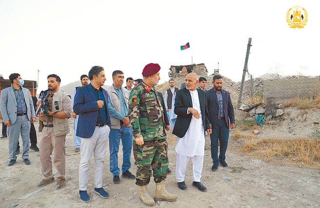 阿富汗总统加尼（右二，穿白衣者）和代理国防部长穆罕默迪（中）14日前往探亲喀布尔的政府军部队，不过塔利班反政府部队15日已从四面八方进入喀布尔市区。（阿富汗总统府发布照片）