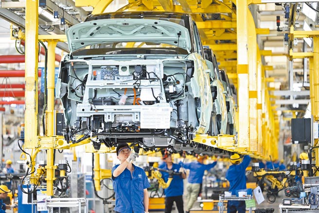 大陆新能源汽车产销大爆发，绿色投资持续升温。图为广西柳州一家汽车企业，工人在新能源汽车生产线上忙碌。（新华社）
