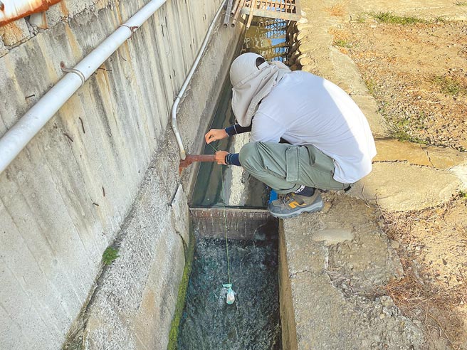 台中市环保局使用「重金属监测离子交换树脂缩时胶囊」，监测农地土壤及灌溉水源污染情况，图为工作人员在沟渠中布设缩时胶囊。（环保局提供／林欣仪台中传真）