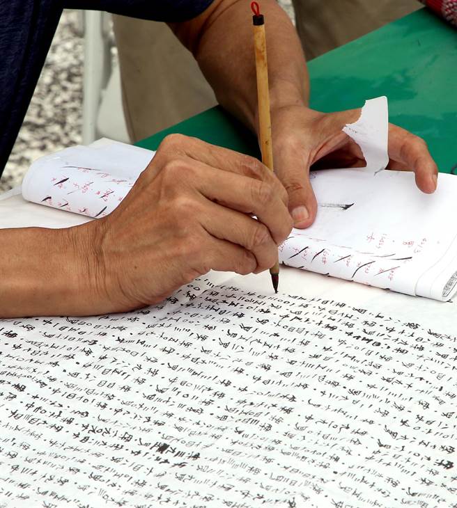 現場書寫因新冠確診死亡的案號，念度亡者。（趙雙傑攝）