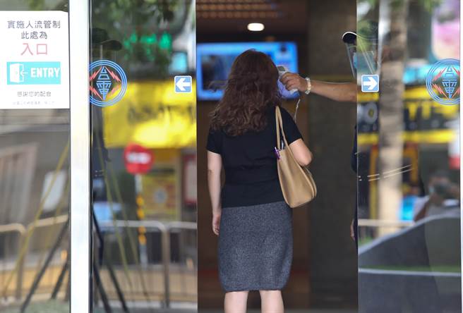 台電傳有同仁確診新冠肺炎，台電大樓加強管制人員，統一出入口，進入一律量溫度。台電員工正常進出大樓，看不出有異樣。(陳俊吉攝)