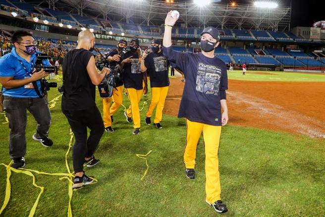 中信兄弟上半季登基封王，在桃园球场抛下黄色彩带，总教练林威助（前一）带领球员绕场，向现场球迷致意。（陈麒全摄）