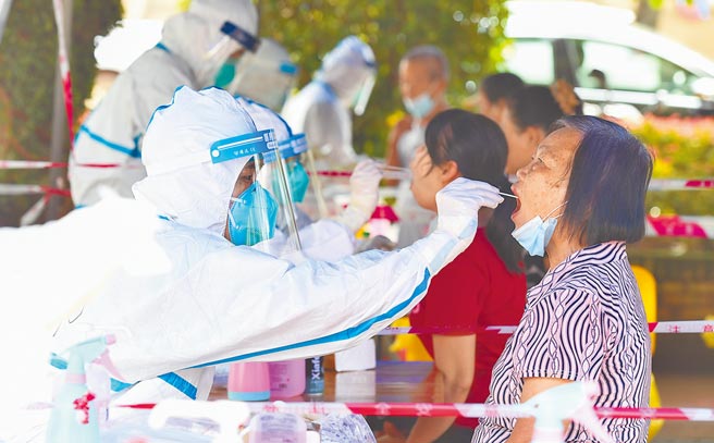 香港政府16日公布，将严加控制从美国等16个海外地区到港人士的检疫要求，将于20日零时起开始实施。图为大陆海南海口的医务人员为居民进行核酸检测取样。（新华社）