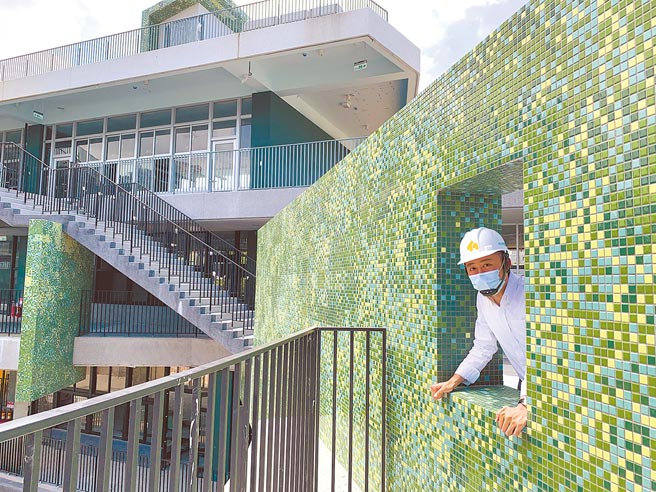 新竹市「龙山国小群英楼」新建筑的草绿色马赛克砖融入周遭老树，远看宛如一片森林。（陈育贤摄）