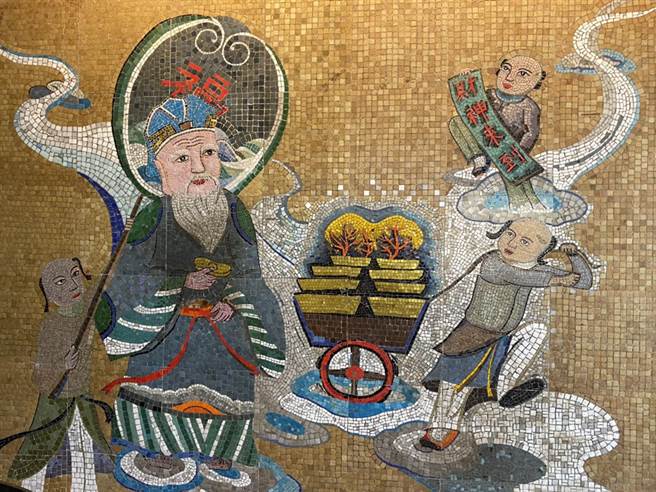 土地公手拿金元寶，一旁童子推著載滿黃金的推車，讓民眾求得好財運。（張亦惠攝）