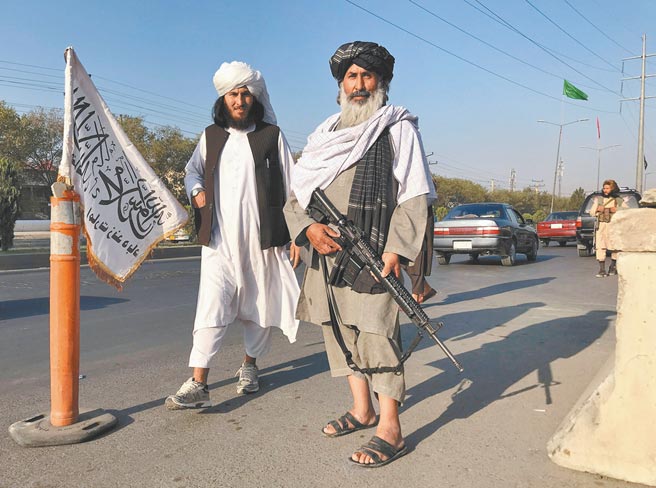 一名手持M16突击步枪的塔利班战士站在阿富汗喀布尔内政部外头。（路透）