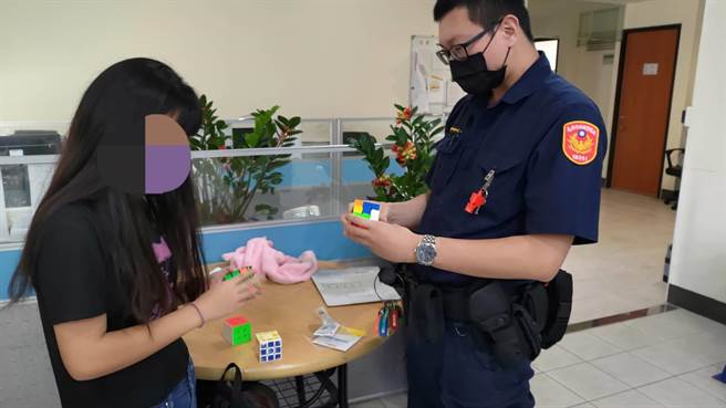捷警李駿逸和女同學PK魔術方塊，藉機轉移遺失錢包的陳生不安的情緒。（讀者提供／石秀華高雄傳真）
