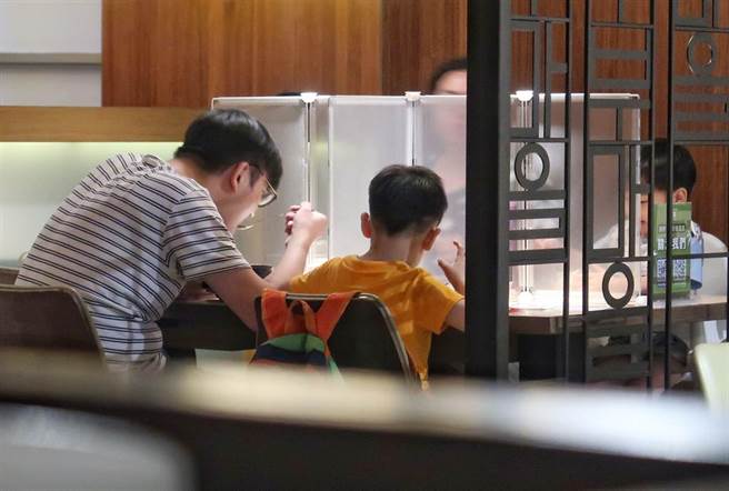 新冠肺炎疫情趨緩，疫情警戒降至2級，也放寬餐飲規範，不過卻有4歲小孩用餐時被要求自己吃個人鍋，引發爭議。中央流行疫情指揮中心19日宣布同住家人共餐規範將放寬。圖為小朋友與家人依防疫規範用餐。（王英豪攝）
