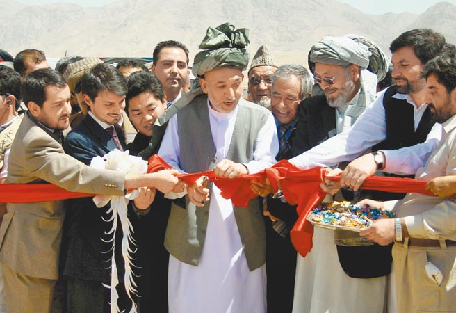 中國不斷向塔利班釋放合作訊號，美媒表示，是謀求合作開發阿富汗的稀土。圖為中國參與修建的邁巴公路動工，阿總統卡爾扎伊（中）出席剪綵。（新華社）
