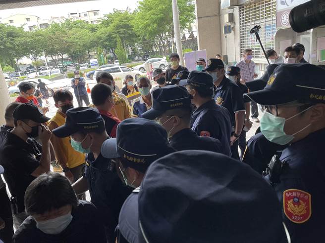 彰化市乔友大楼6月30日晚间大火4人命丧火窟，今天殉难消防家属、消防工作权益促进会在县广场要真相，不满县府只派消防局秘书接受陈情书，被警察阻拦在侧门入口，僵持１个多小时。（吴敏菁摄）