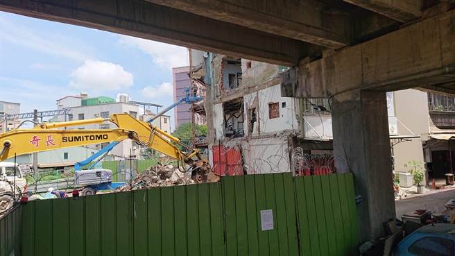 黄家门窗已铁皮焊封，挖土机开始拆除作业。（程炳璋摄）