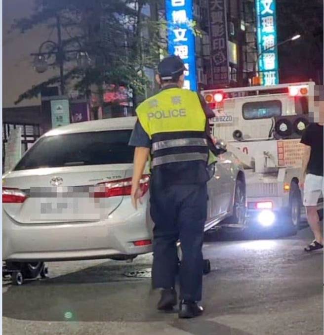 高雄市1名车主违停，车子被拖吊上了溜冰鞋后，车主还试图开车门拦阻，警方告知此举已涉嫌妨害公务，车主才乖乖松手。（翻摄脸书爆料公社／石秀华高雄传真）