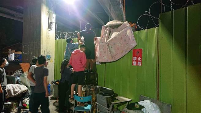 声援学生与民眾铺棉被欲越过铁丝网墙，高喊铁道局停工。（程炳璋摄）
