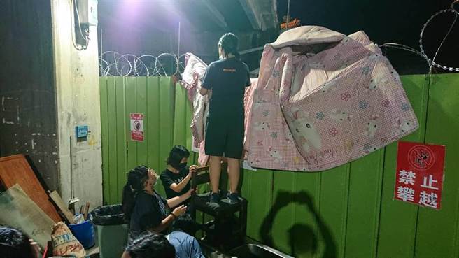 黄家声援者情绪高亢，迭棉被要越过铁丝网墙。（程炳璋摄）
