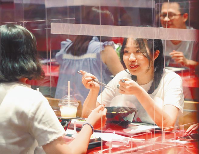 为救疫情重创的餐饮业，行政部门研议数位五倍券餐饮加码。图为民眾20日在餐厅设立的隔板间用餐。（郑任南摄）