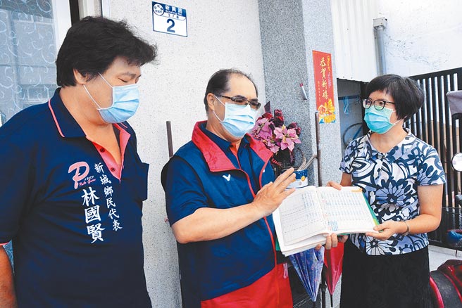 新城国小校长黄丽花（右）特地带来「金牌教练」奖座与当年毕业纪念册，向林敬能（中）致意，感谢「杰出校友」对举重体育的付出，图左为林敬能同学乡代林国贤。（王志伟摄）