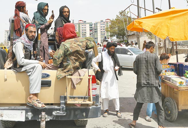 塔利班表示已完全掌控阿富汗，民兵成员在喀布尔街头向小贩购物。儘管塔利班承诺，不会针对曾为北约和前政府效力的阿国人民秋后算帐，但据联合国秘件，塔利班已针对这些人，展开挨家挨户的搜索行动。（新华社檔案照片）