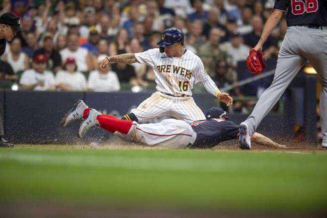 酿酒人寇顿王(球衣16号)滑回本垒，国民一垒手齐玛曼触杀不及。（美联社）