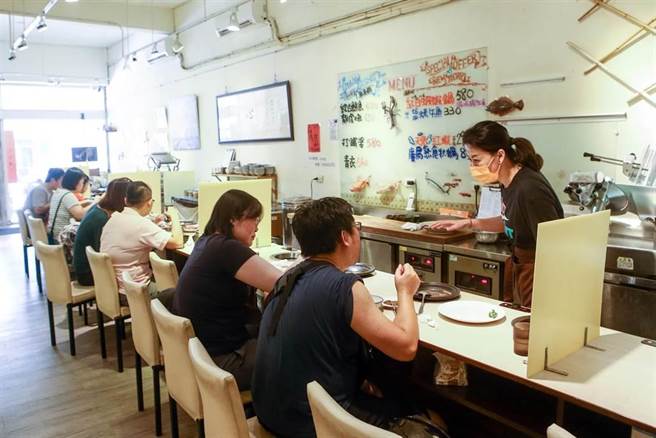 時序雖已進入立秋，但中午仍天氣炎熱，許多民眾在週休二日時外出用餐，進入有冷氣的火鍋店，吃著火鍋也讓身體的熱氣冒出。中央疫情指揮中心日前宣布，二級警戒再延長到9月6日和多項鬆綁措施，除了同住親友可在餐廳免隔板共餐外，也無需梅花座、專人分菜。（鄧博仁攝）
